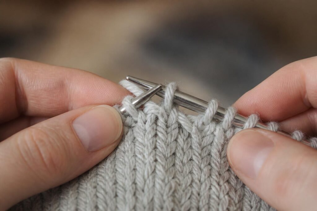 découvrez comment réaliser un surjet double au tricot, une technique de diminution invisible qui apporte finesse et élégance à vos ouvrages.